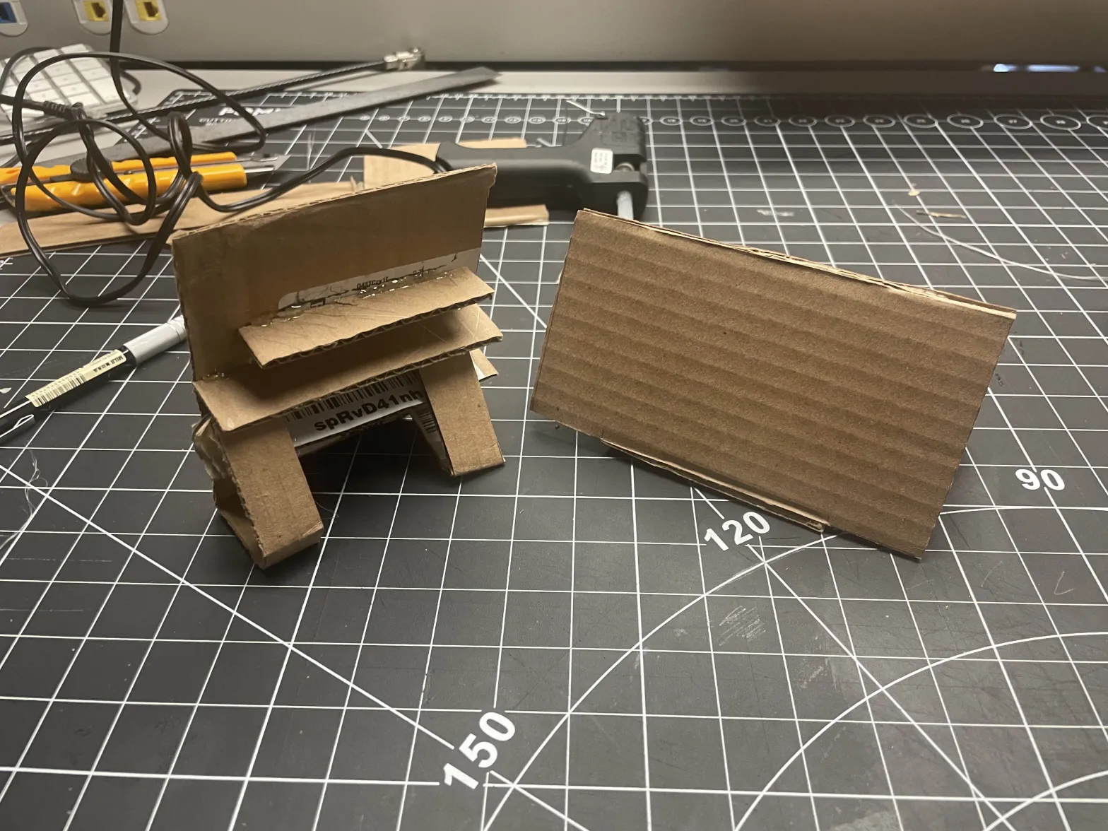 The back of both phone stands. The main iterations we made included a lip on the front of the stand to prevent the phone from slipping off, and an adjustable height with the use of the 2 arms